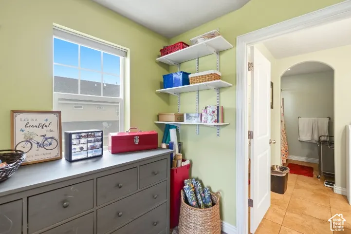 Room featuring white adjustable wall-mounted shelving and a single-hung window with a screen