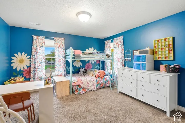 Neutral-toned wall-to-wall carpeting, flush-mount ceiling lighting, and dual windows providing natural light