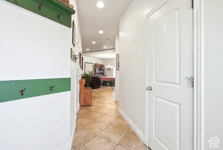 Entryway featuring tile flooring, built-in wall-mounted coat hooks, and recessed lighting