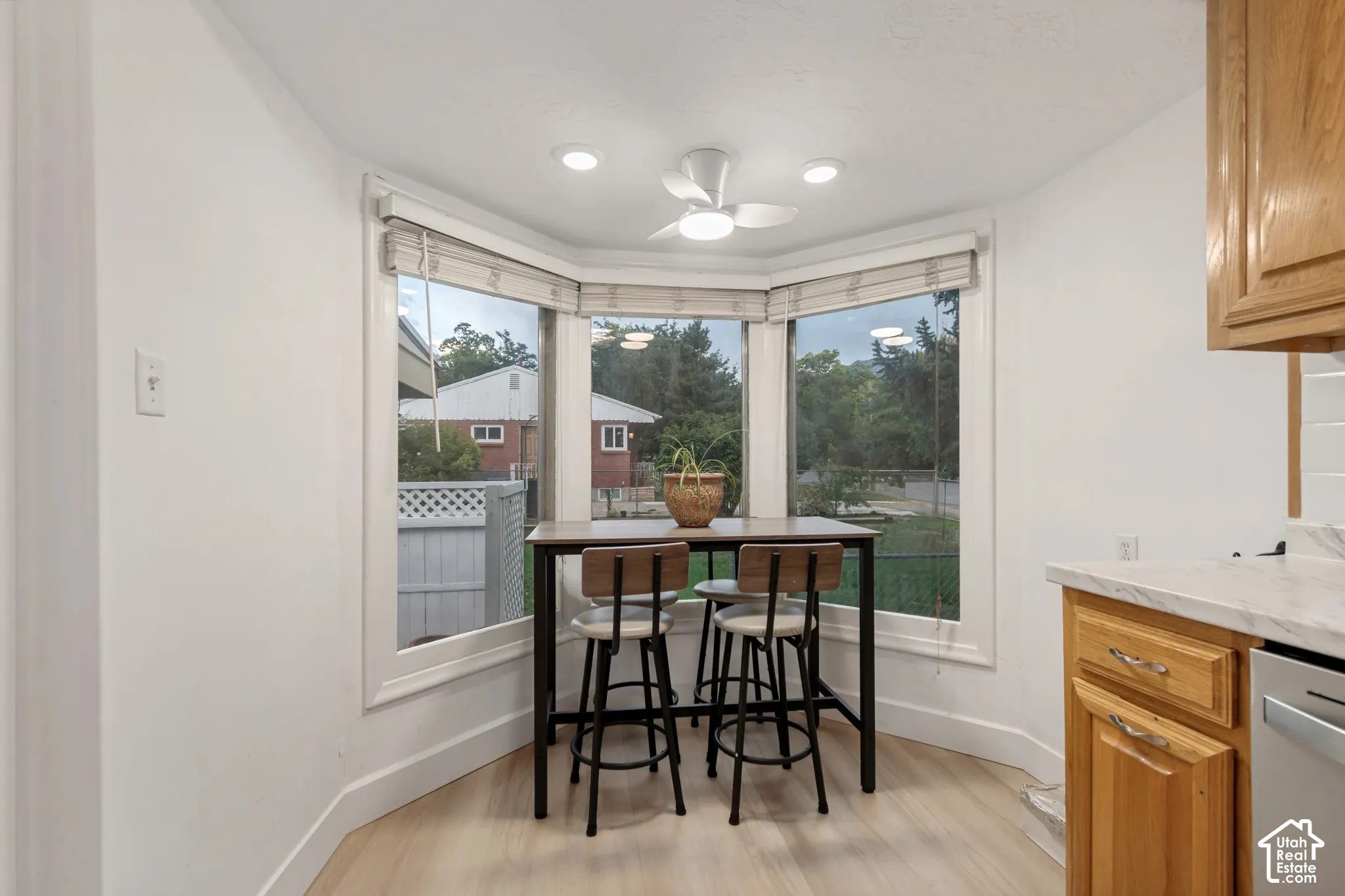 Bay window featuring expansive glazing, natural wood-finish cabinetry, stone-patterned laminate countertops, and ceiling-mounted directional lighting