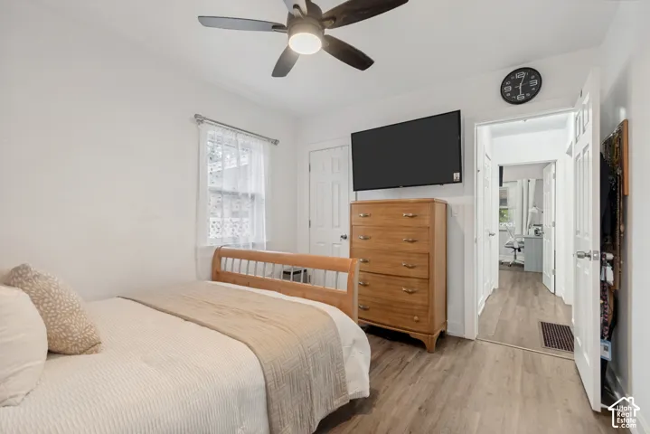 Wood-finish flooring, ceiling fan with integrated lighting, and multi-panel interior doors