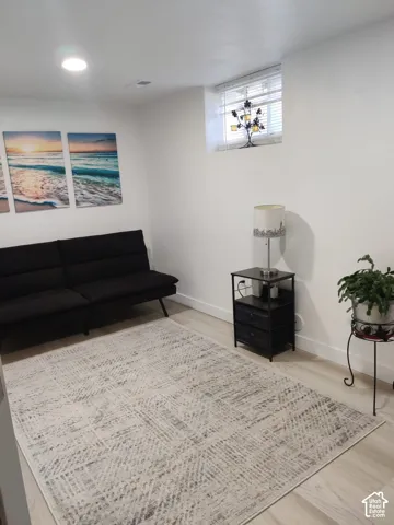 Light-toned wood-finish flooring, recessed lighting, and a recessed window with integrated blinds
