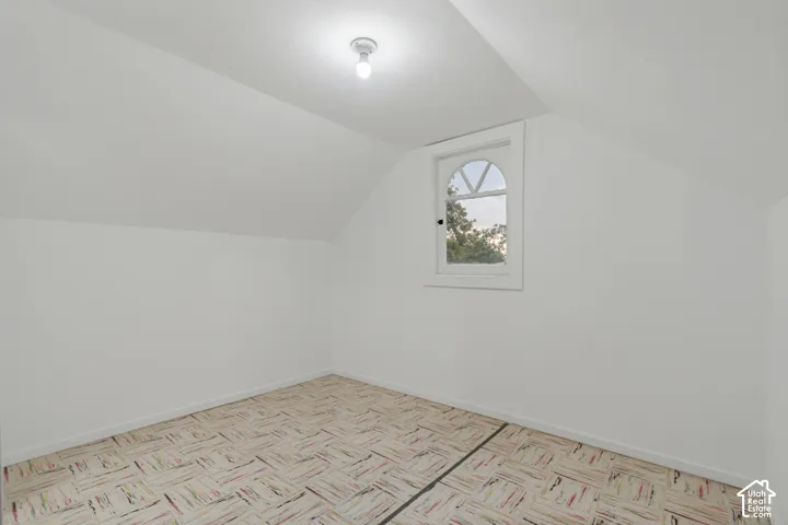 Sloped ceilings, arched window with divided lites, and parquet-style flooring