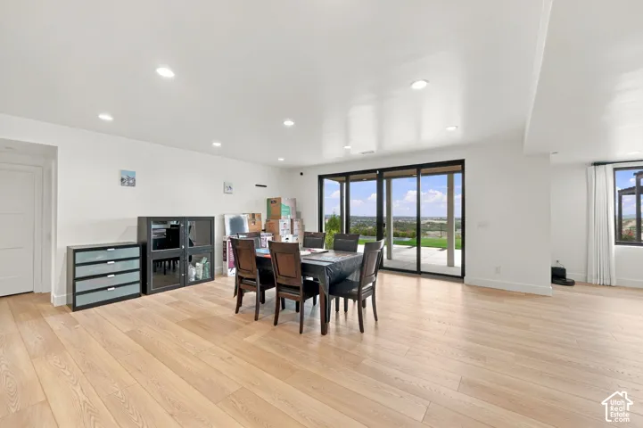 Open-concept living space featuring wood-finish flooring, recessed lighting, and expansive floor-to-ceiling sliding glass doors