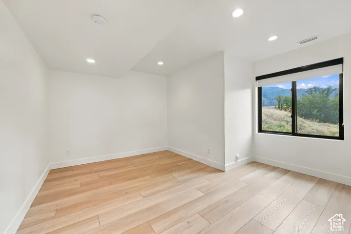 Room featuring wood-finish flooring, recessed lighting, and a window with mountain scenery