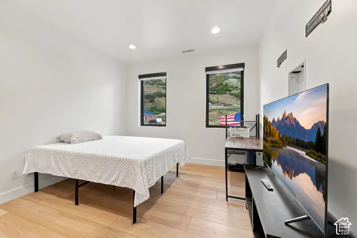 Wood-finish flooring, recessed lighting, and windows with mountain scenery
