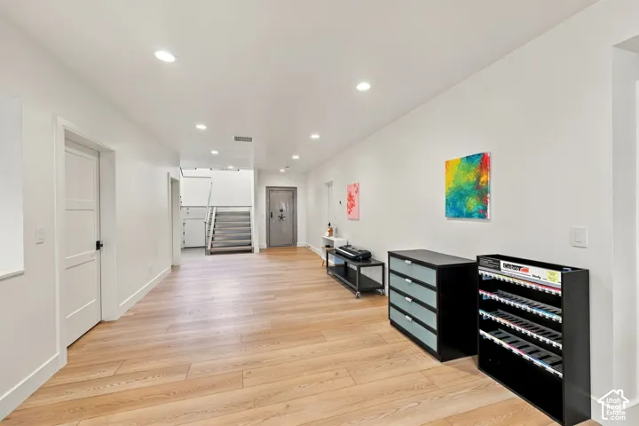 Interior space featuring wood-finish flooring, recessed lighting, and a metal security door