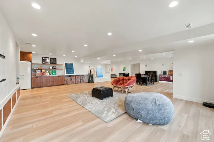 Open-concept living space featuring wood-finish flooring, recessed lighting, and custom wood-finished cabinetry