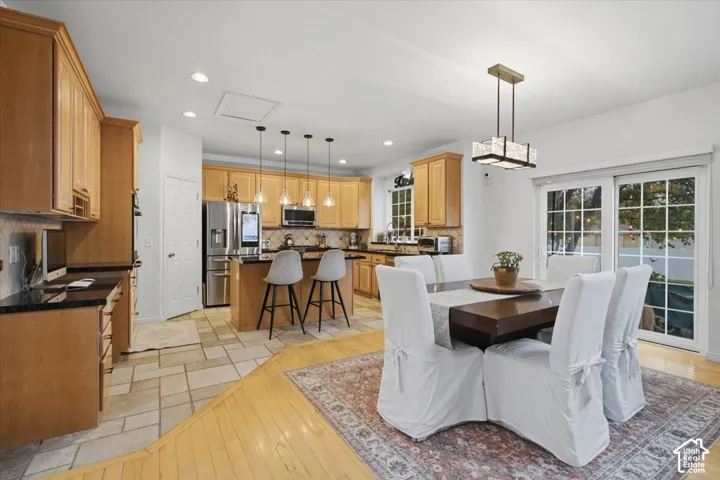 Kitchen featuring natural wood cabinetry, stone-finish countertops, tile flooring, recessed lighting, and a multi-pendant light fixture over the island