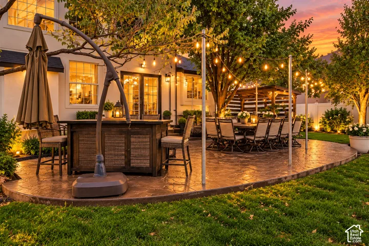 Stamped concrete patio featuring an integrated wood-frame pergola and string lighting