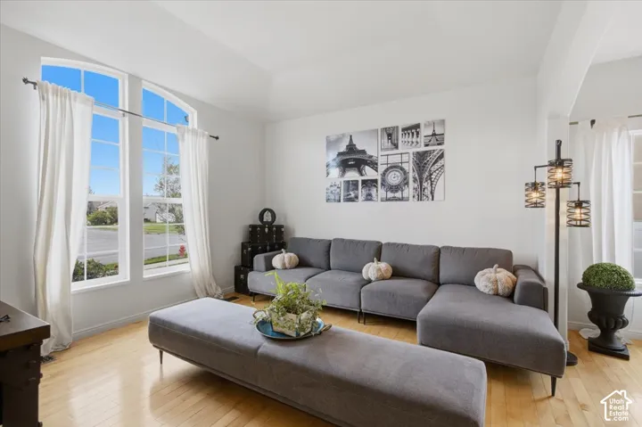 Vaulted ceilings, tall windows with arched transoms, and light-tone wood-finish flooring