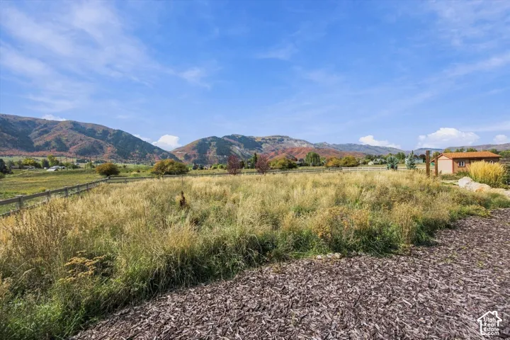 Expansive lot featuring mountain backdrops, wood-post fencing, and natural terrain