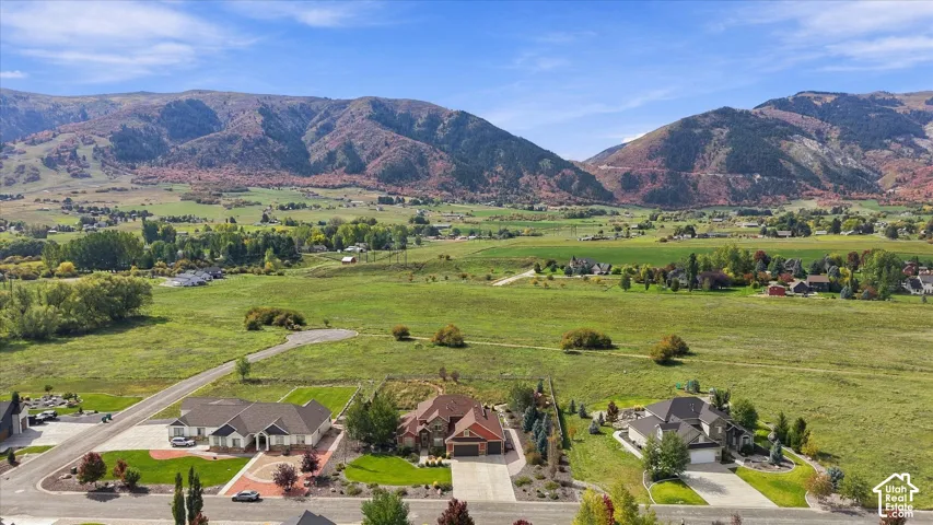Aerial perspective of properties featuring multi-gabled rooflines, stone and brick masonry, multi-car garages, and expansive mountain backdrops