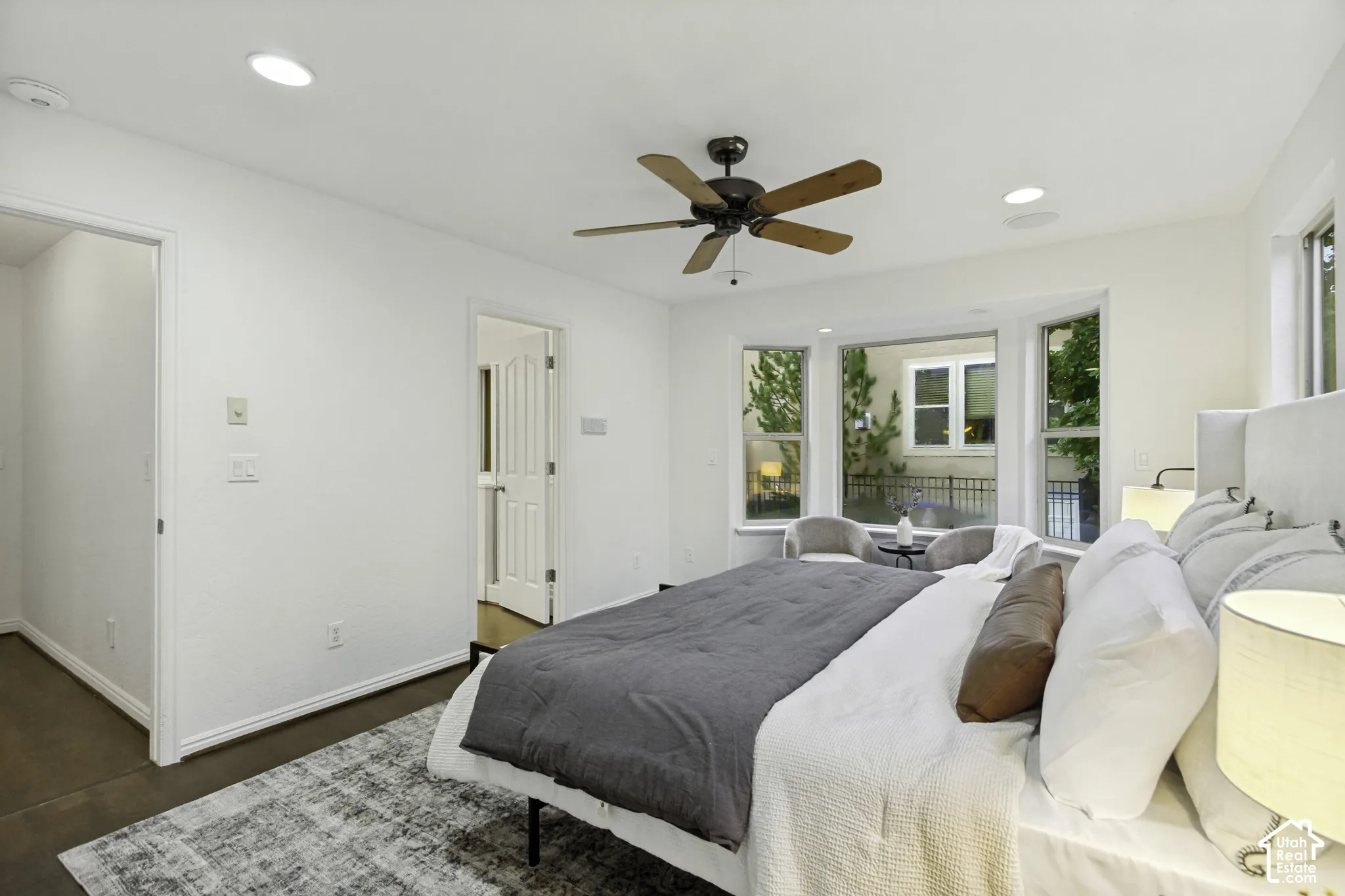 Bedroom featuring wood-finish flooring, recessed lighting, multi-pane bay windows, and a ceiling fan with wooden blades