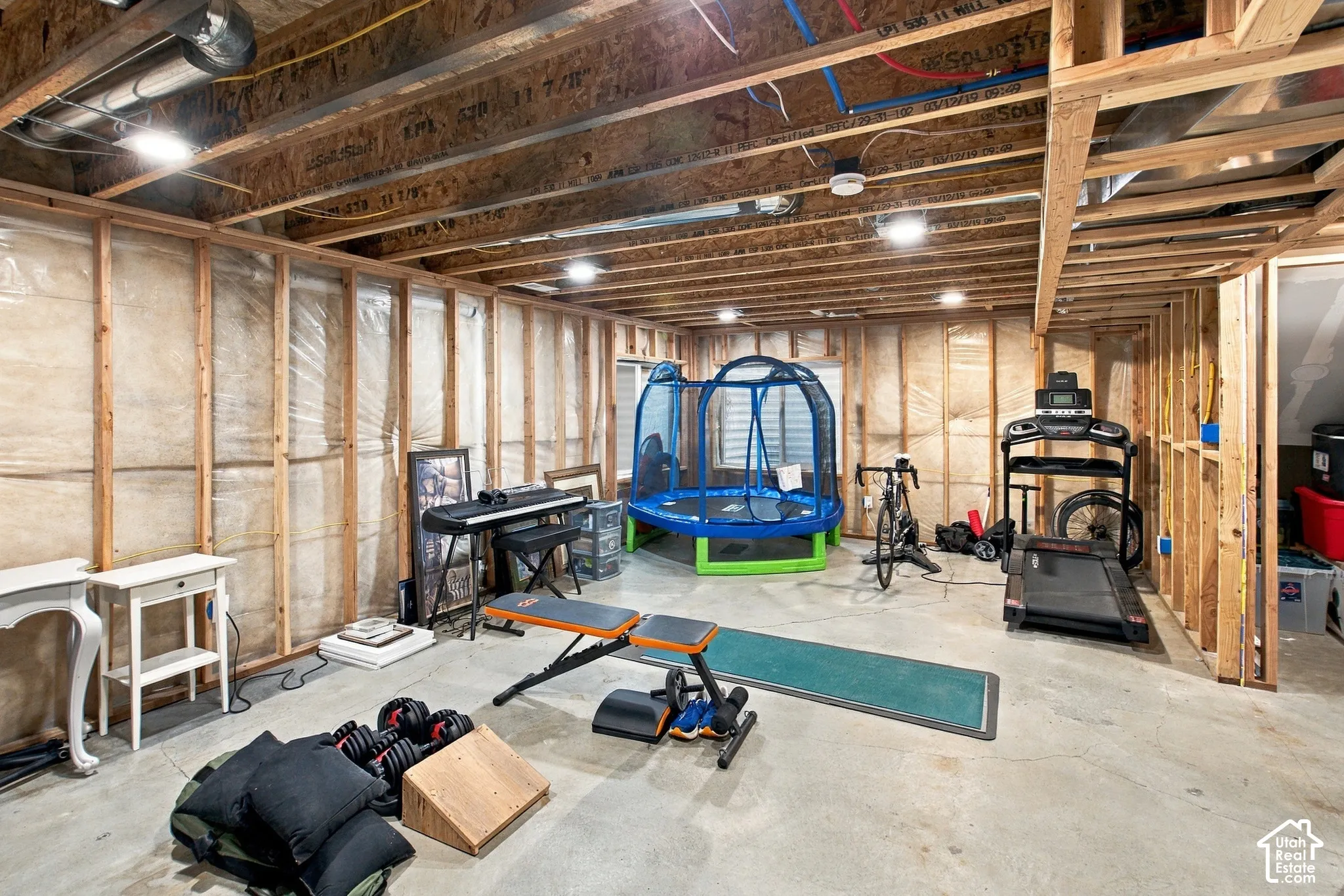 Unfinished lower level featuring exposed wood-stud framing, concrete flooring, and exposed ceiling joists