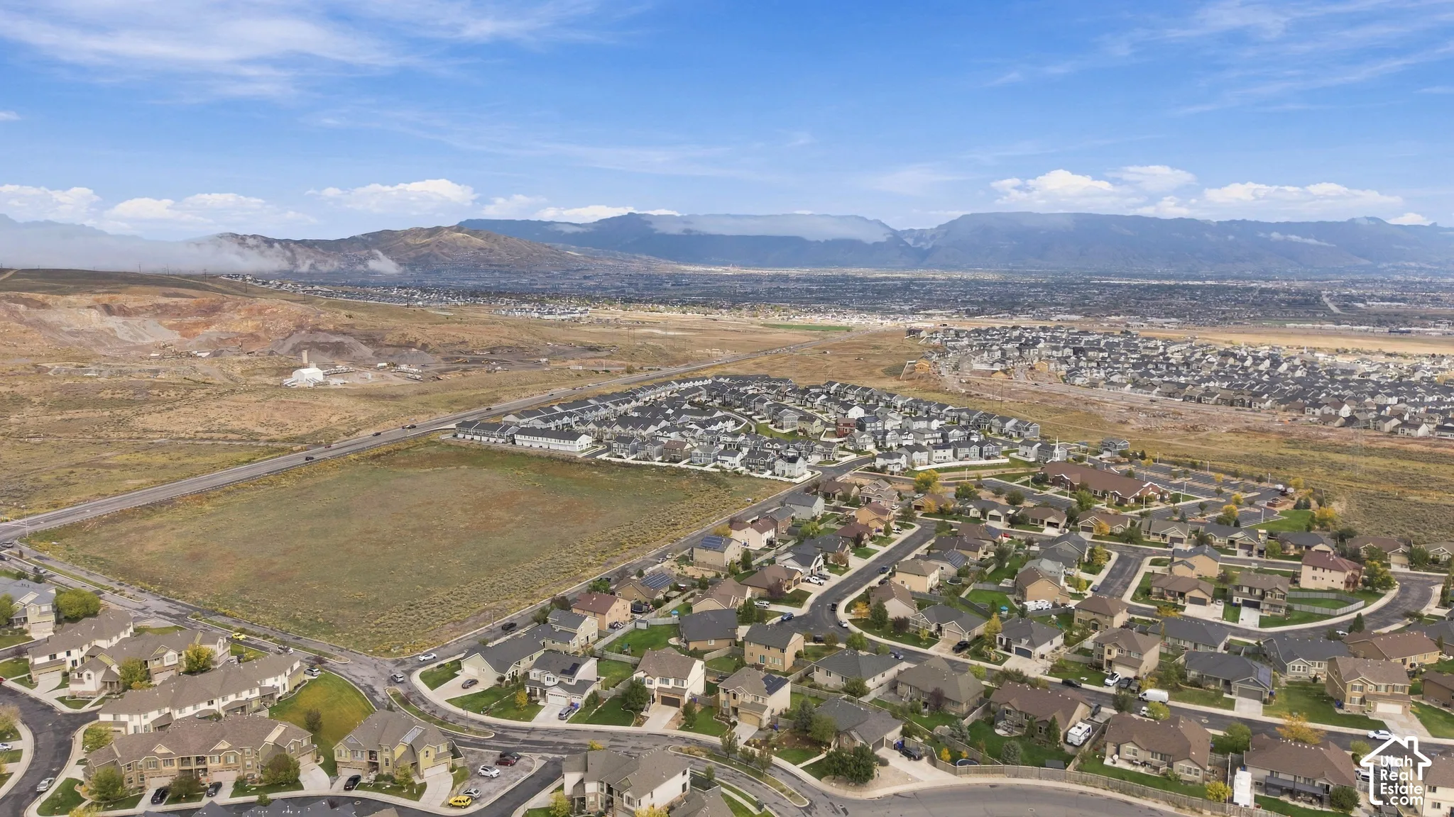 Aerial view of the residential community featuring paved roads, established landscaping, and a mountain backdrop
