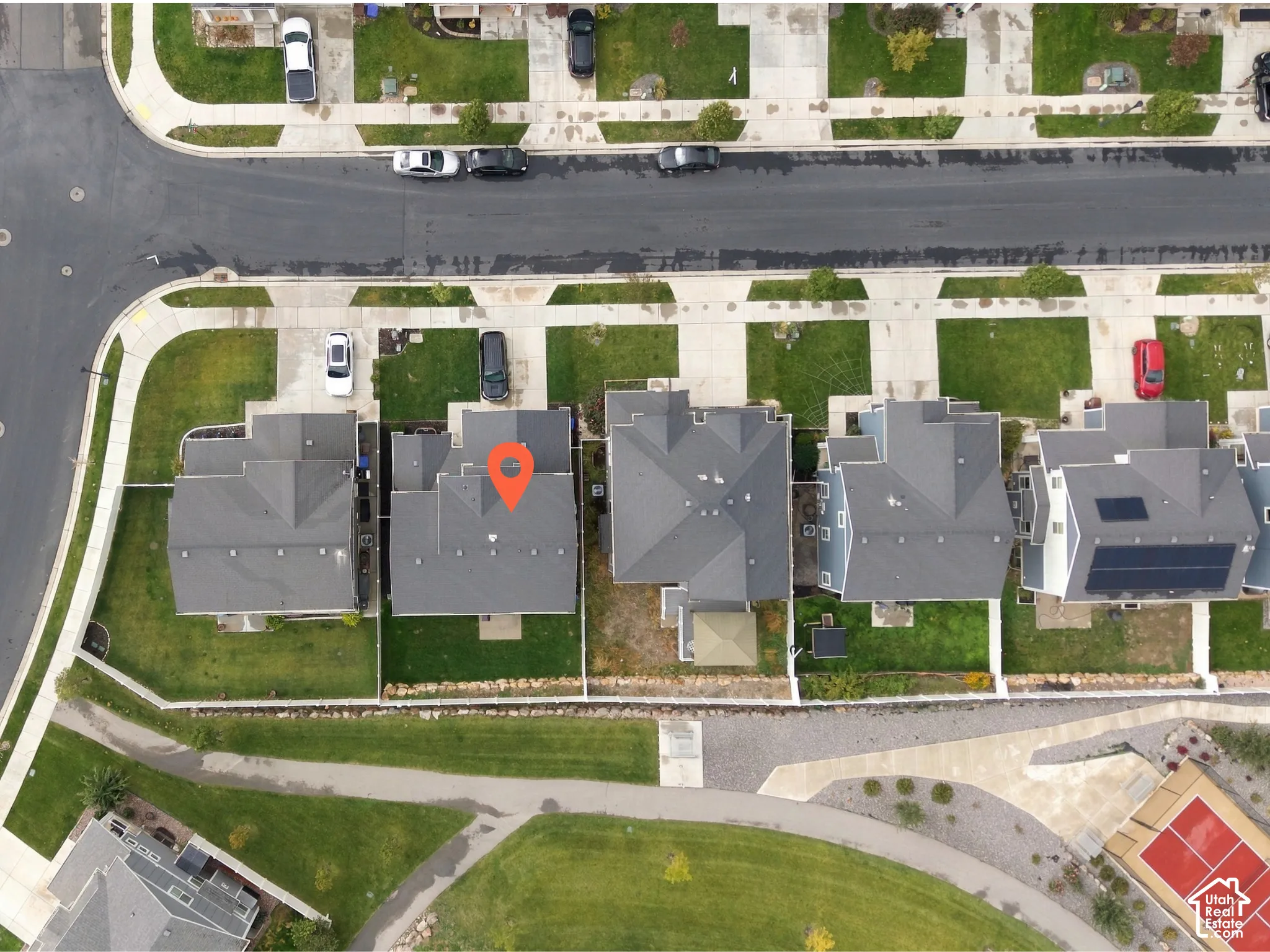 Aerial perspective of corner lot featuring a fenced backyard, concrete patio, and direct access to an adjacent paved walking path