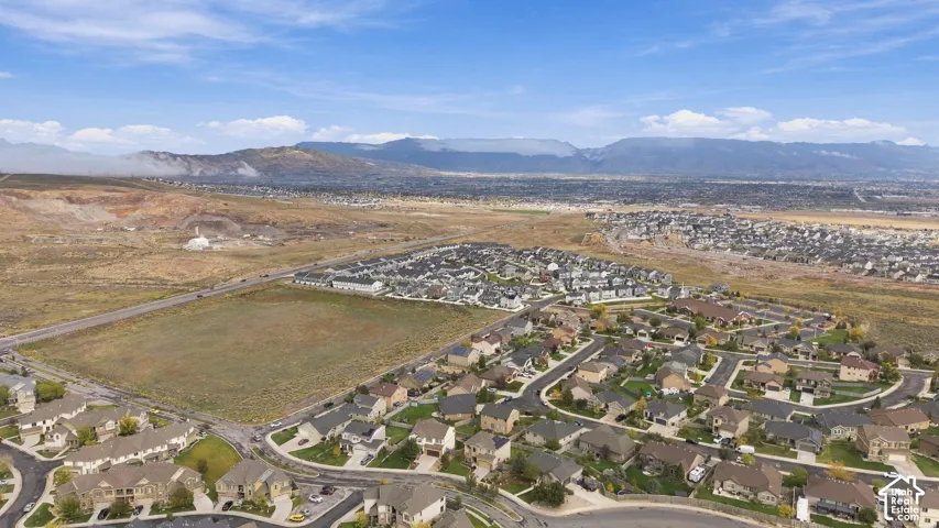 Aerial view of the residential community featuring paved roads, established landscaping, and a mountain backdrop