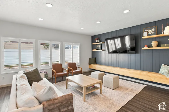 Dark vertical shiplap accent wall with integrated floating wood-finish bench and matching tiered shelving, recessed lighting, and white plantation shutters