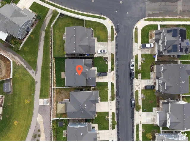 Corner lot location featuring a fenced backyard, concrete driveway, and direct access to a paved pedestrian walkway