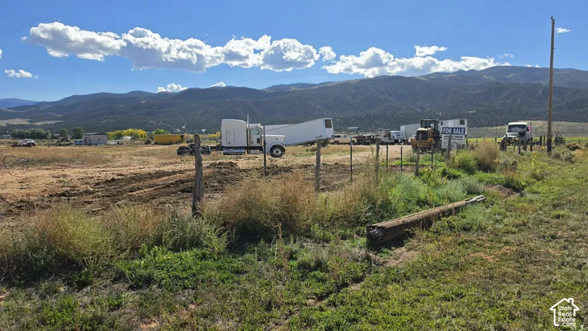 Expansive acreage featuring wire fencing and prominent mountain range backdrop