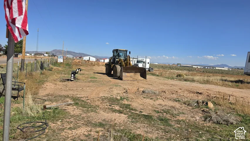Expansive plot of land featuring natural terrain and distant mountain backdrops