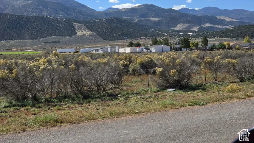 Expansive lot featuring native high-desert vegetation, mountain backdrops, and established perimeter fencing