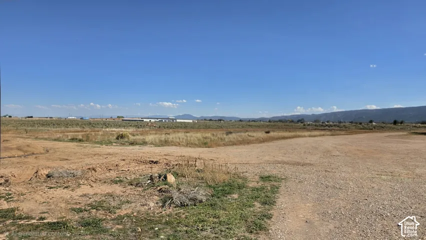 Expansive plot of land featuring natural desert terrain, gravel access, and mountainous horizon