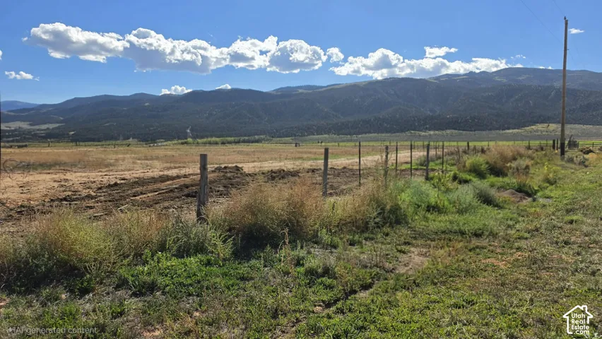 Expansive open acreage featuring post-and-wire fencing and prominent mountain backdrops