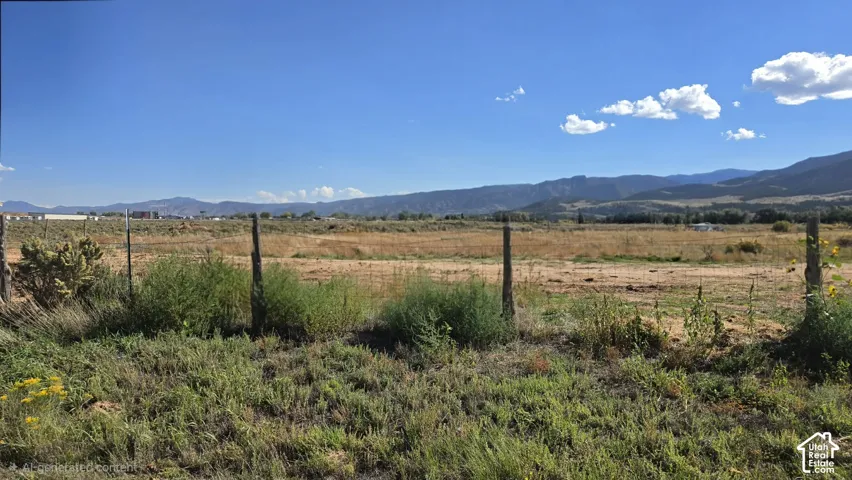 Expansive lot featuring native terrain, perimeter wire fencing, and prominent mountain backdrops