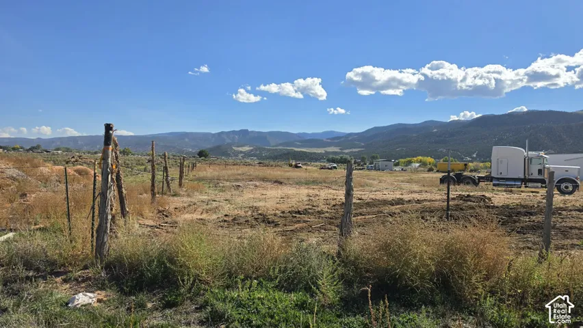 Expansive acreage featuring natural terrain, rugged fencing, and prominent mountain backdrops