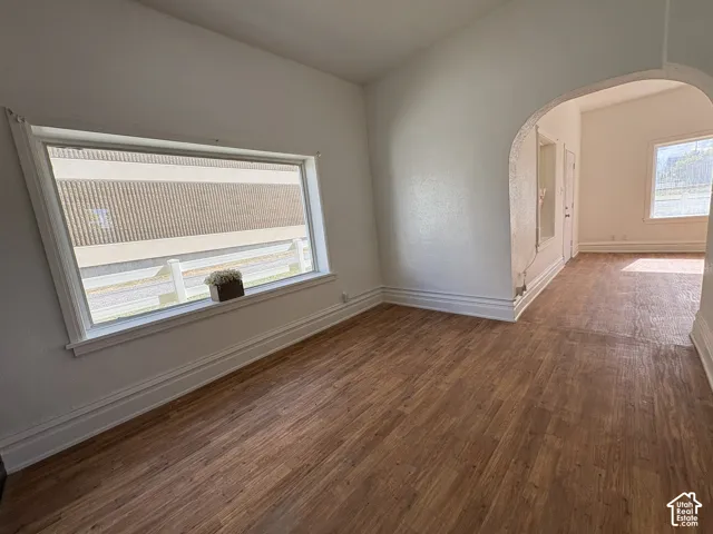 Interior space featuring wood-finish flooring, an arched entryway, and a large horizontal window