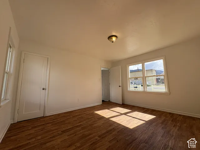 Room featuring wood-finish flooring, dual-pane windows, and a ceiling-mounted light fixture