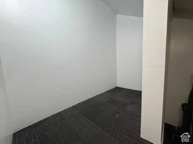 Neutral-toned walls and dark, patterned carpet tiles