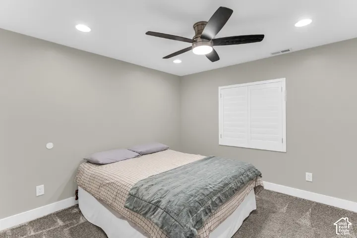 Room featuring neutral wall paint, recessed lighting, carpeted flooring, a ceiling fan with integrated lighting, and white plantation shutters