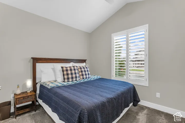 Vaulted ceiling, neutral wall color, and window with plantation-style shutters