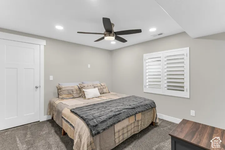 Neutral-toned interior featuring recessed lighting, a multi-blade ceiling fan, wall-mounted plantation shutters, and a shaker-style interior door