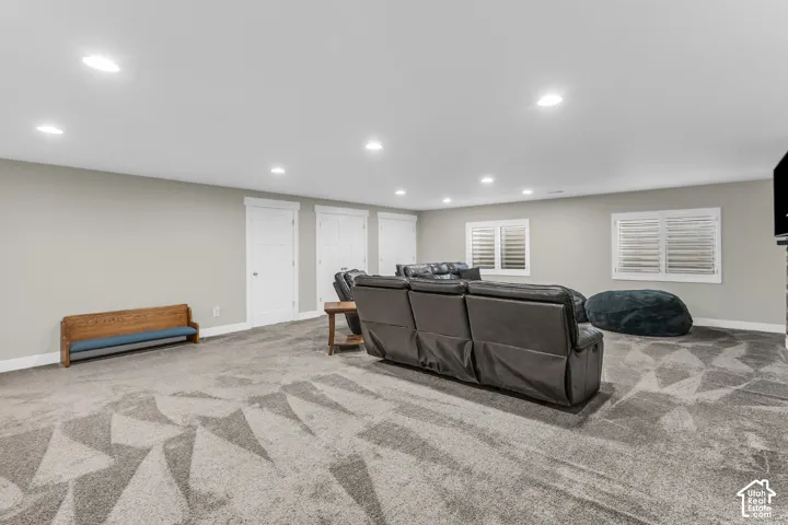 Spacious interior featuring recessed lighting, patterned wall-to-wall carpeting, multiple closet doors, and windows finished with plantation-style shutters