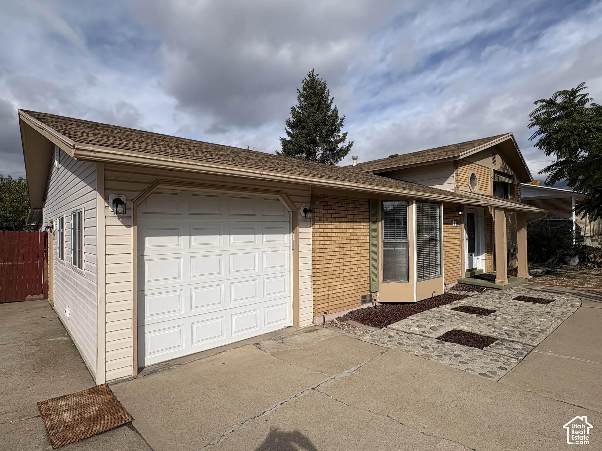 Exterior featuring horizontal siding, brick masonry, bay window, and a stone-accented entryway