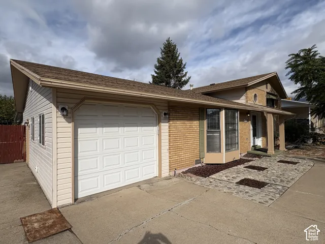 Exterior featuring horizontal siding, brick masonry, bay window, and a stone-accented entryway