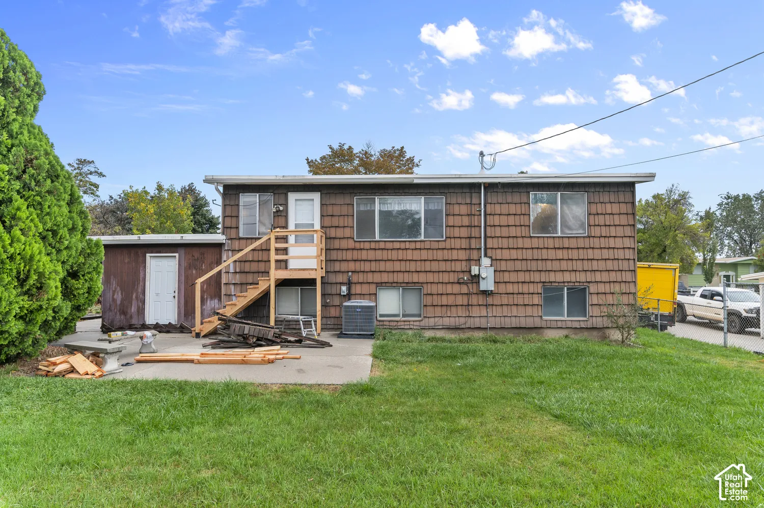 Exterior featuring shingle siding, concrete patio, and elevated wood staircase