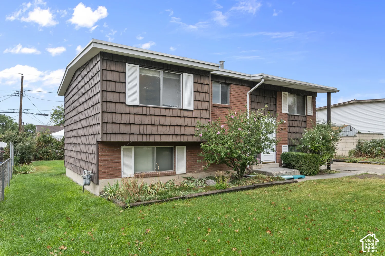 Exterior featuring a combination of brick and shake siding, white window shutters, and a covered entryway