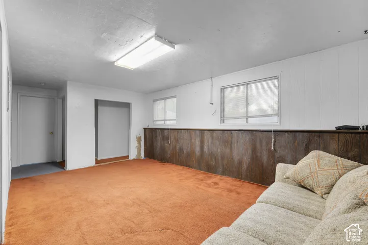 Interior space featuring horizontal wood-panel wainscoting, two sliding windows, and a flush-mount rectangular light fixture
