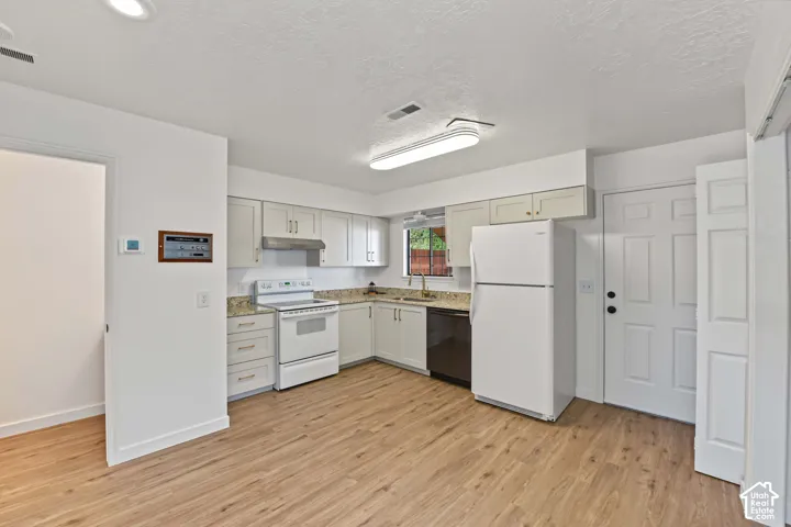 Kitchen featuring light-toned cabinetry, stone-finish countertops, wood-finish flooring, and recessed ceiling lighting