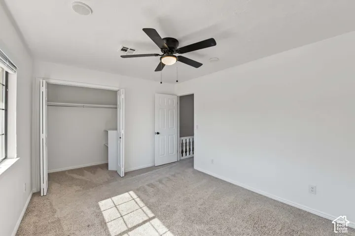 Bedroom featuring neutral carpet flooring, a ceiling fan with integrated lighting, recessed lighting, and a bi-fold door closet