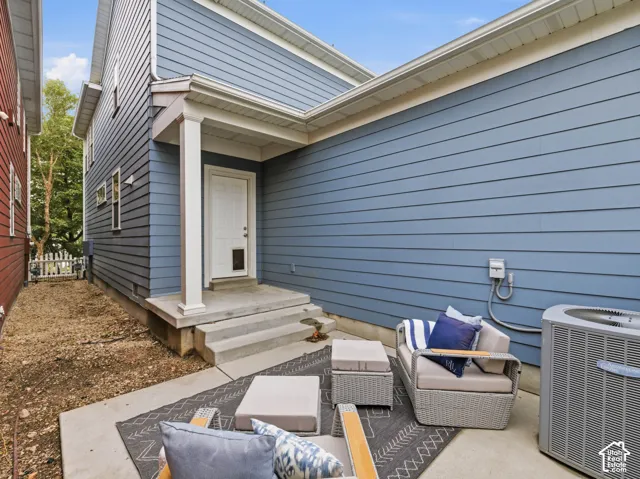 Blue horizontal lap siding exterior featuring a covered porch, concrete stoop, and central HVAC unit