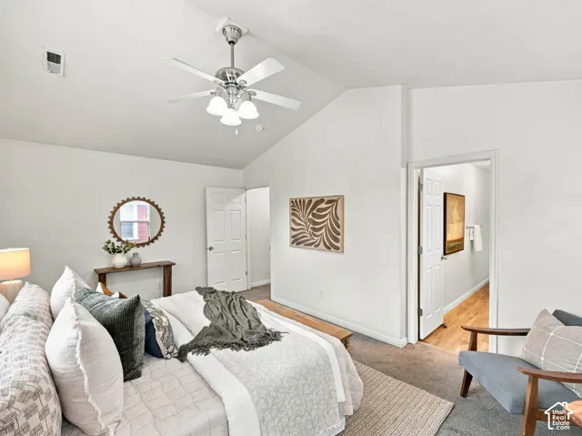 Vaulted ceilings featuring a brushed-nickel ceiling fan with integrated lighting and neutral carpeting