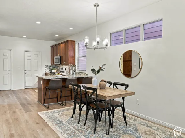 Kitchen area featuring wood-finish cabinetry, stone countertops, and recessed lighting, complemented by wood-finish flooring and clerestory windows