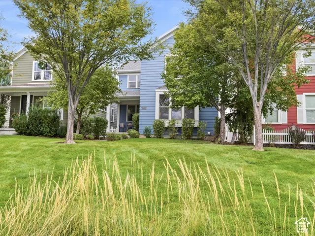 Two-story blue horizontal lap siding exterior featuring multiple front-facing gables, large multi-pane windows, and a covered entryway