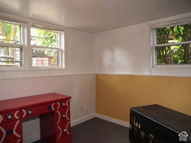 Interior room featuring multiple double-hung windows, two-tone wall finish with chair rail, and wall-to-wall carpeting